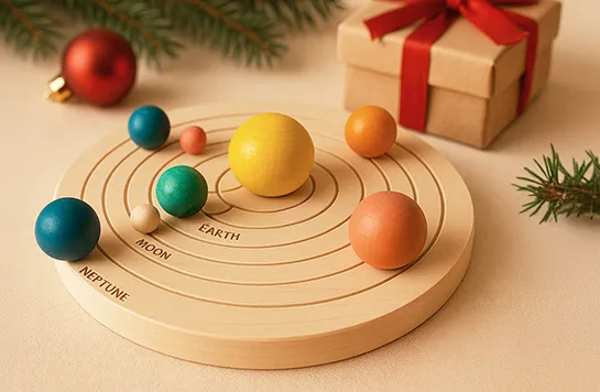 Ein rundes Holzspiel mit bunten Planet Kugeln liegt neben einem Weihnachtsgeschenk